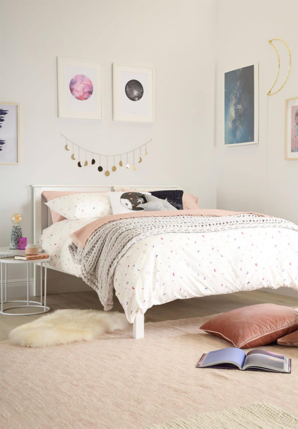 A cosmic space inspired bedroom with metal garlands and art on the walls.