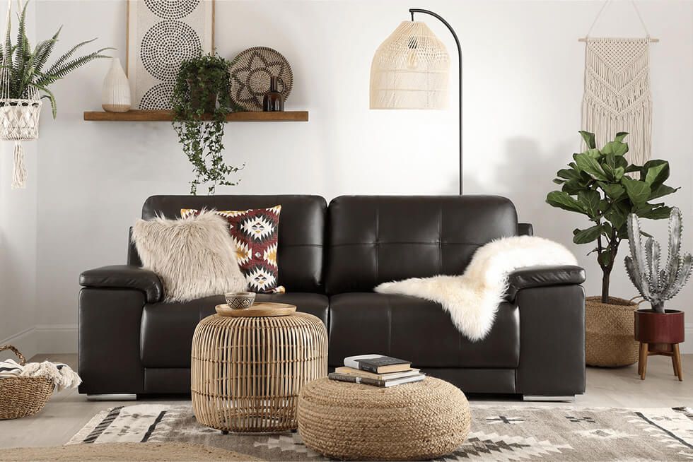 Modern boho earth tone living room with black leather sofa