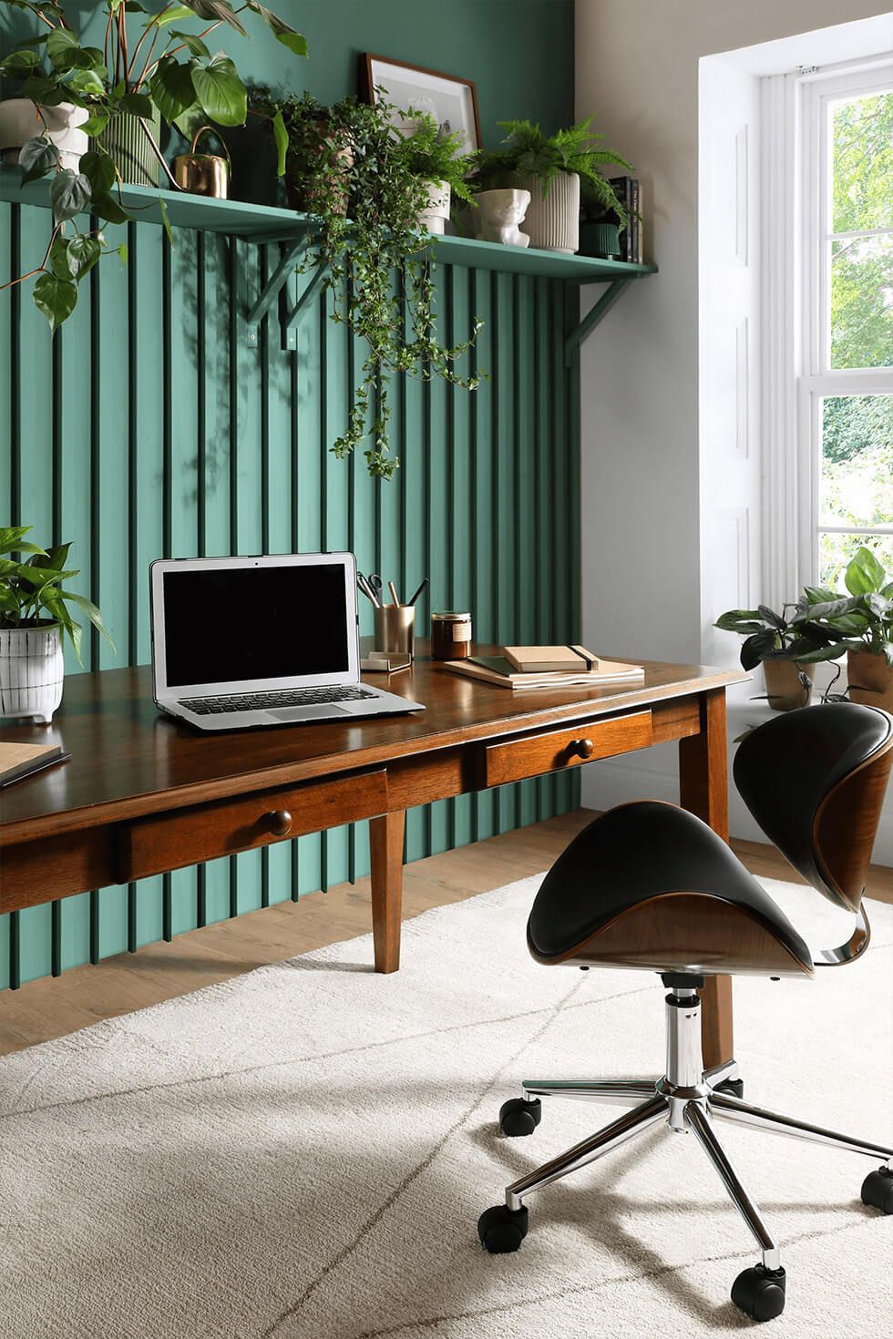 Home office with calming green walls and wooden desk