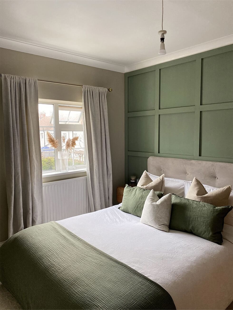 Cosy olive green bedroom with fabric bed and wall panelling