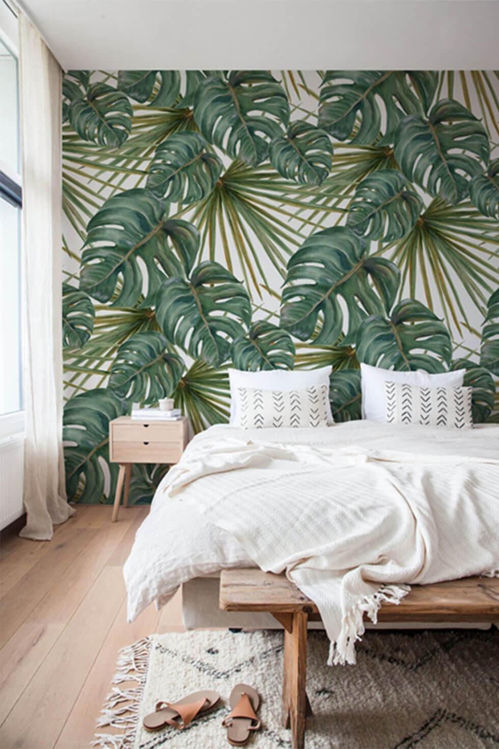 Tropical green bedroom with exotic leaf print wallpaper.