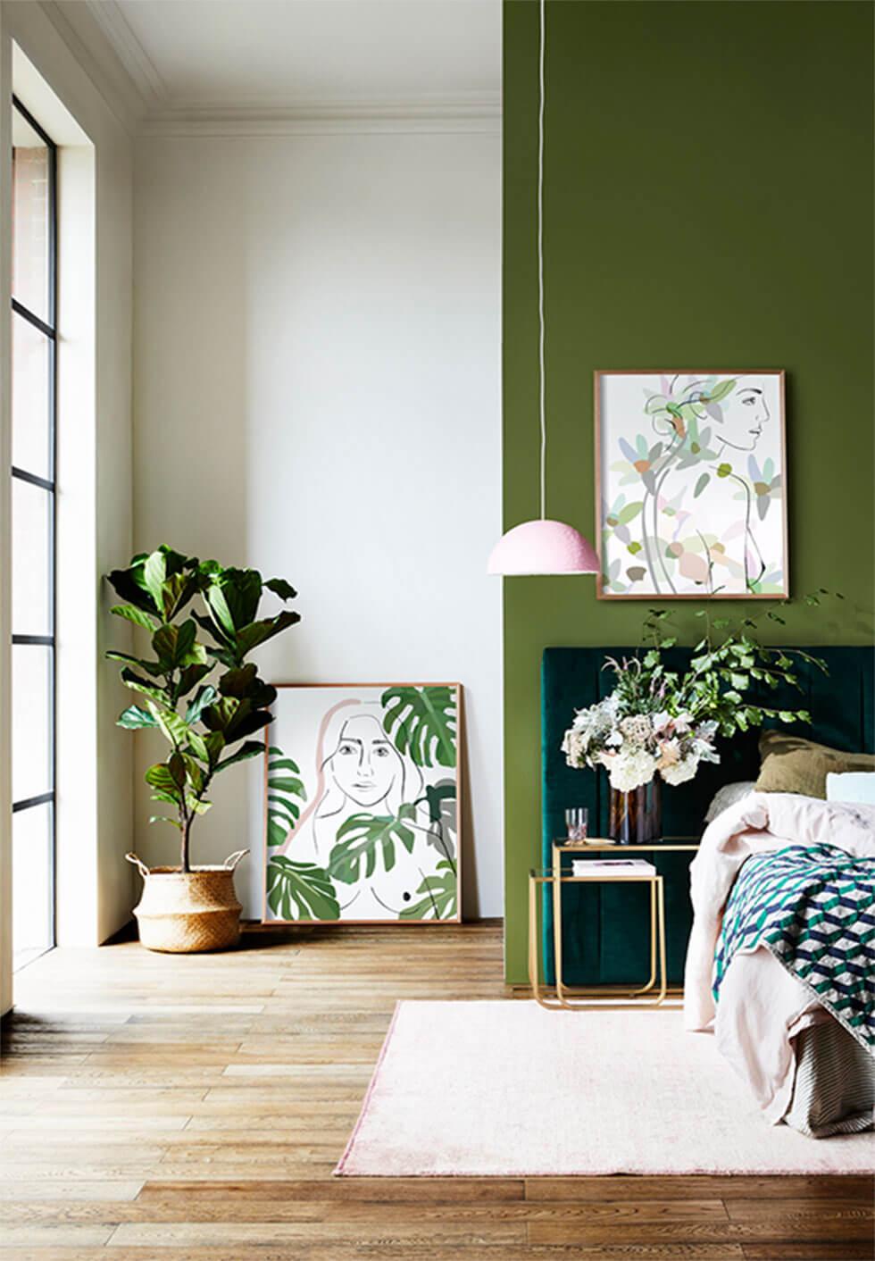 Light green bedroom with indoor plants and green artwork.