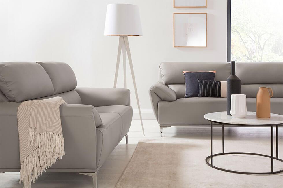 Minimalist living room with taupe leather sofas and round marble coffee table