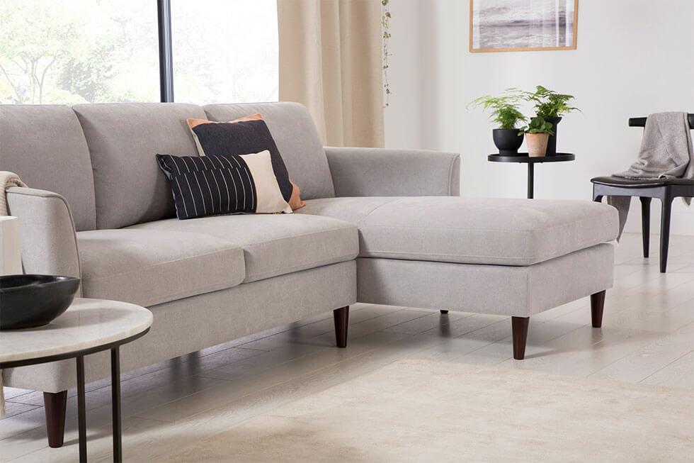 A minimalist living room with a grey corner sofa