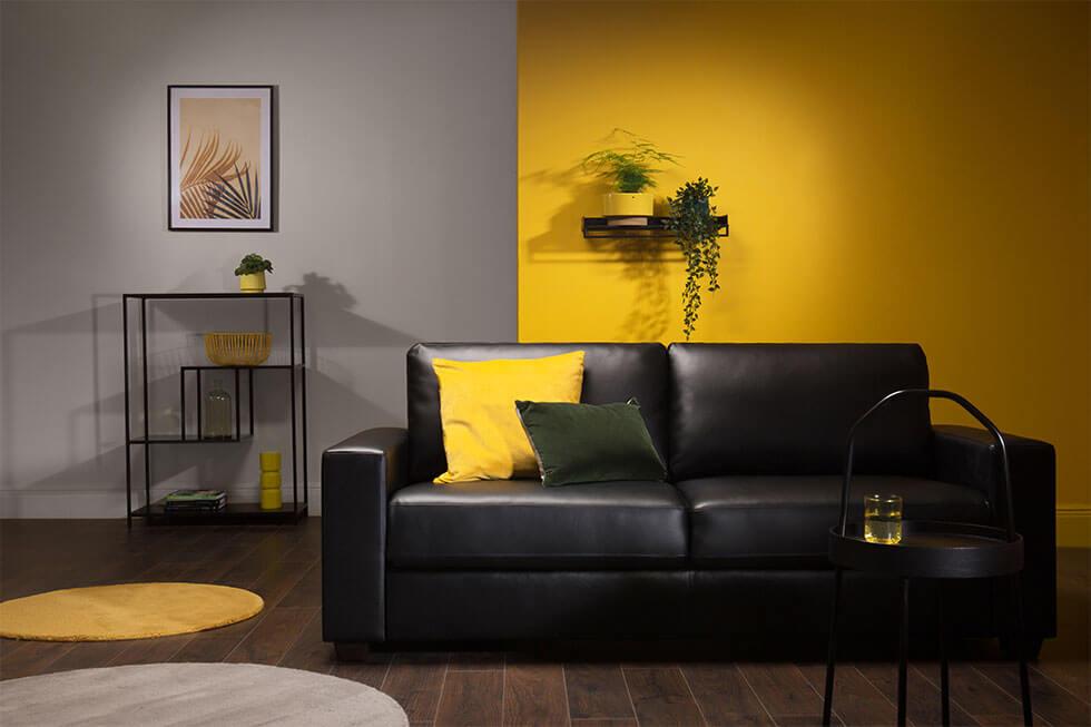 Yellow and grey modern living room with a black leather sofa