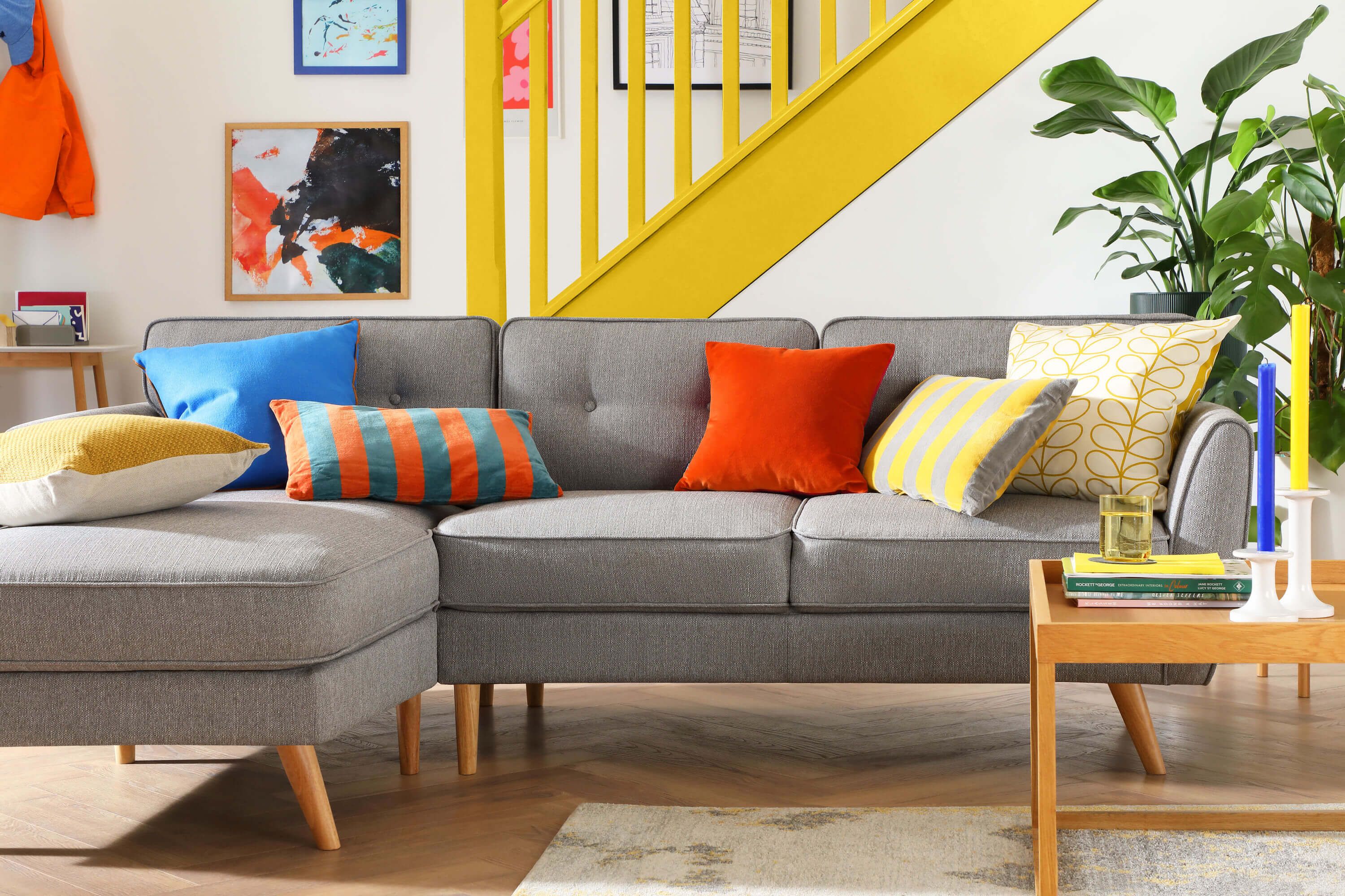 Grey fabric sofa in a bright and modern living room with yellow accents