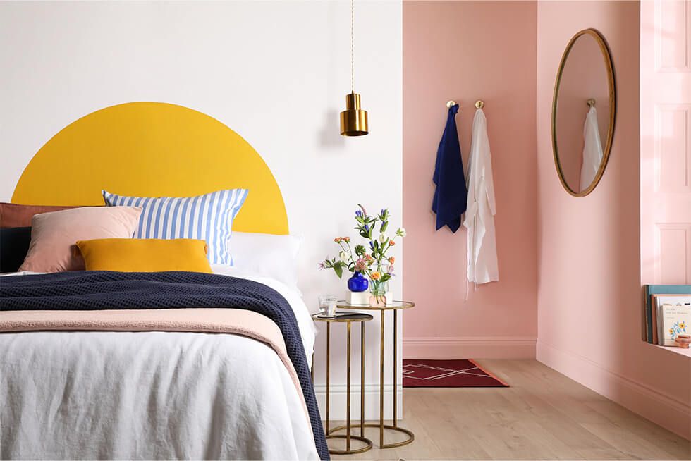 Small bedroom with a yellow feature wall and pink pastel walls