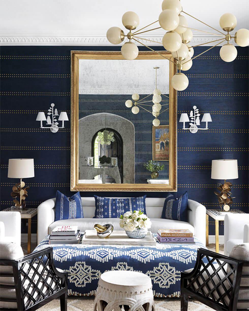 A dark blue living room with a modern chandelier and white sofa.