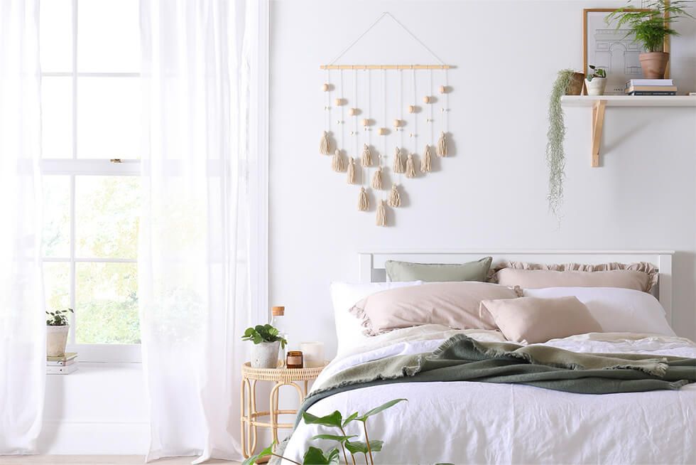 A white bedroom with sheer curtains and natural light