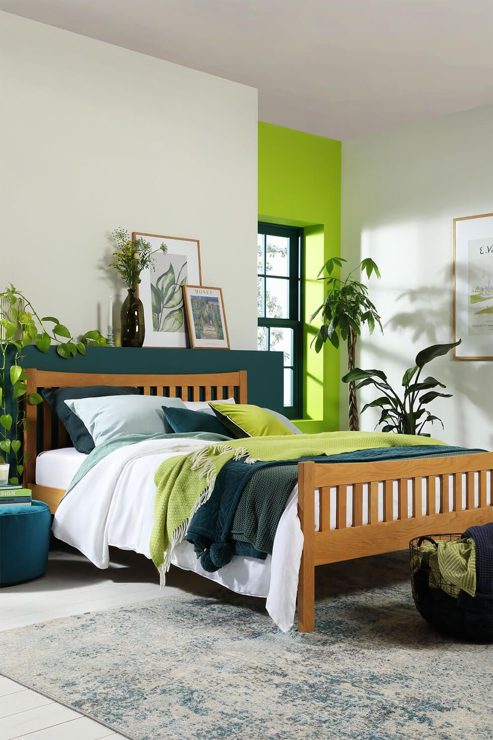 A green bedroom with an oak bed and indoor plants