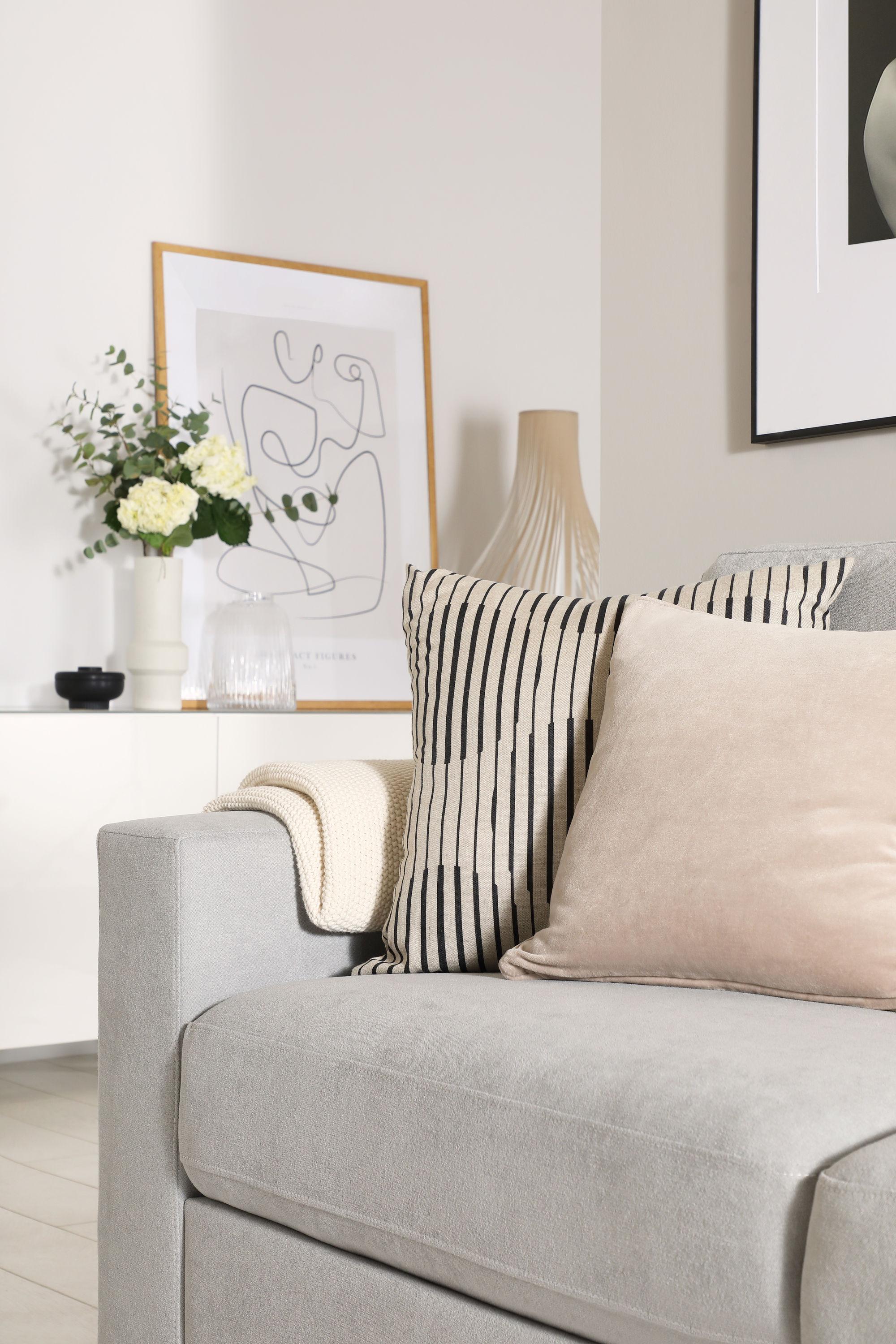 Neutral living room with grey fabric sofa and framed art