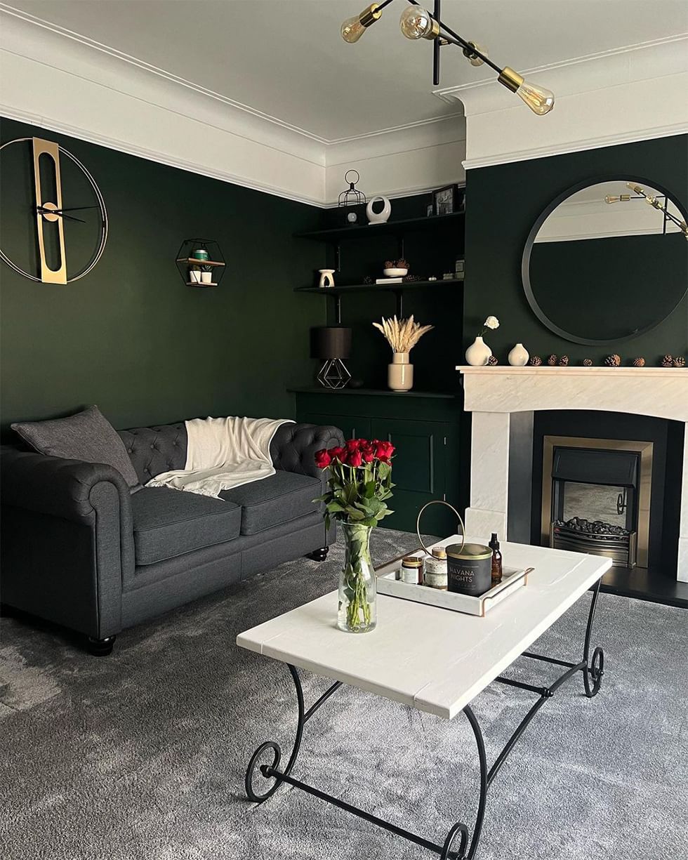 Dark green living room with dark grey Chesterfield sofa