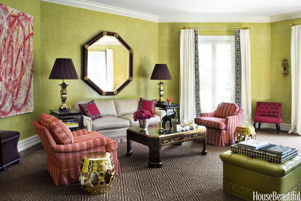 Light green living room with large mirror, brass accents and red armchairs