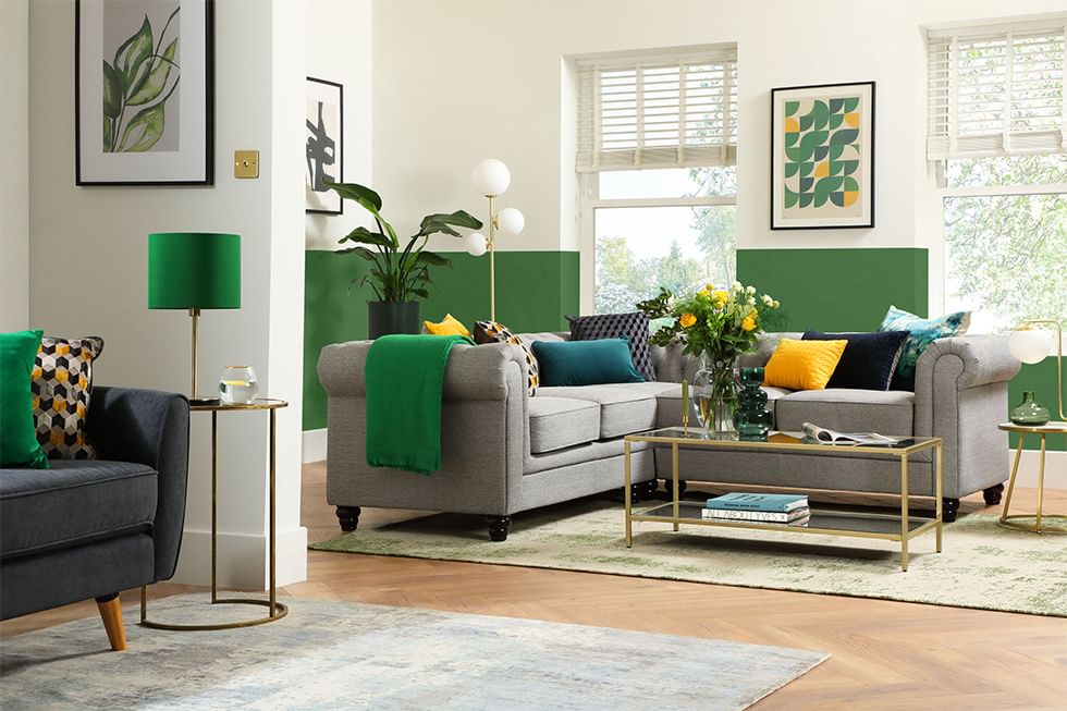 Two-tone green wall with grey sofa and colourful cushions in the living room