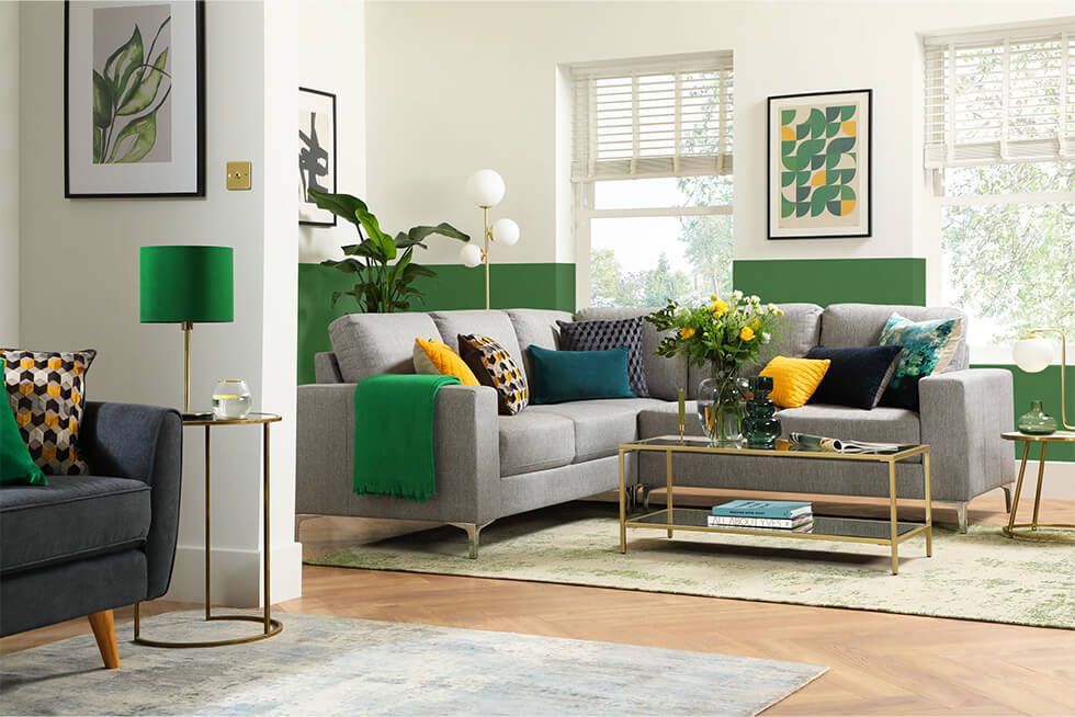 Two-tone green wall with grey sofa and colourful cushions in the living room