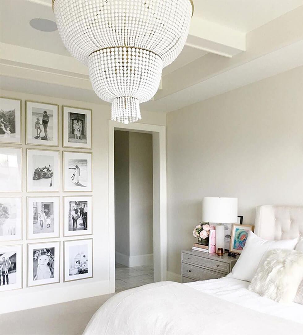 White bedroom with gallery wall of black and white photos.