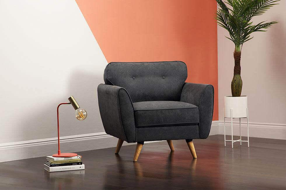 grey armchair in front of a coral geometric colour blocked wall