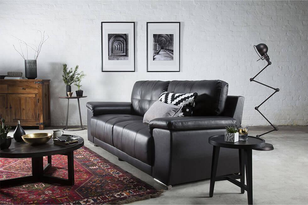 black leather sofa in an industrial style living room with exposed brick wall