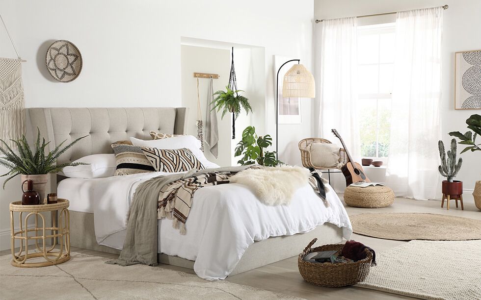 A bohemian style bedroom with textured accessories and potted plants