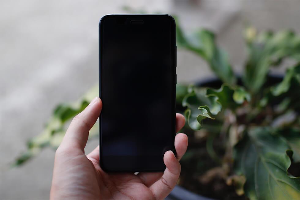 Black mobile phone that's switched off to focus on mindful living.