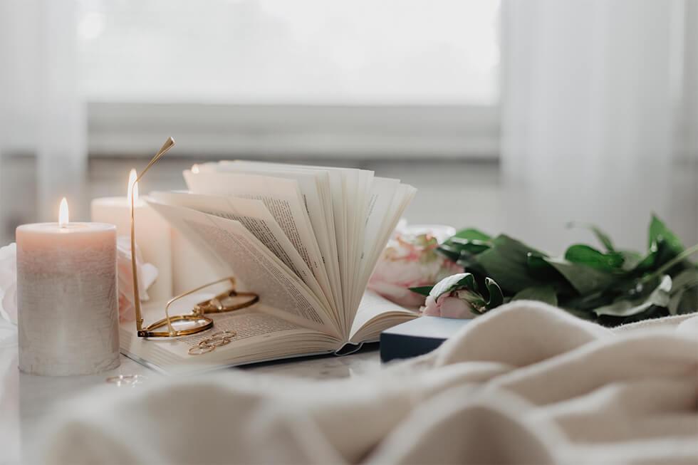 Candles, plants, and a book in a wellness inspired room.