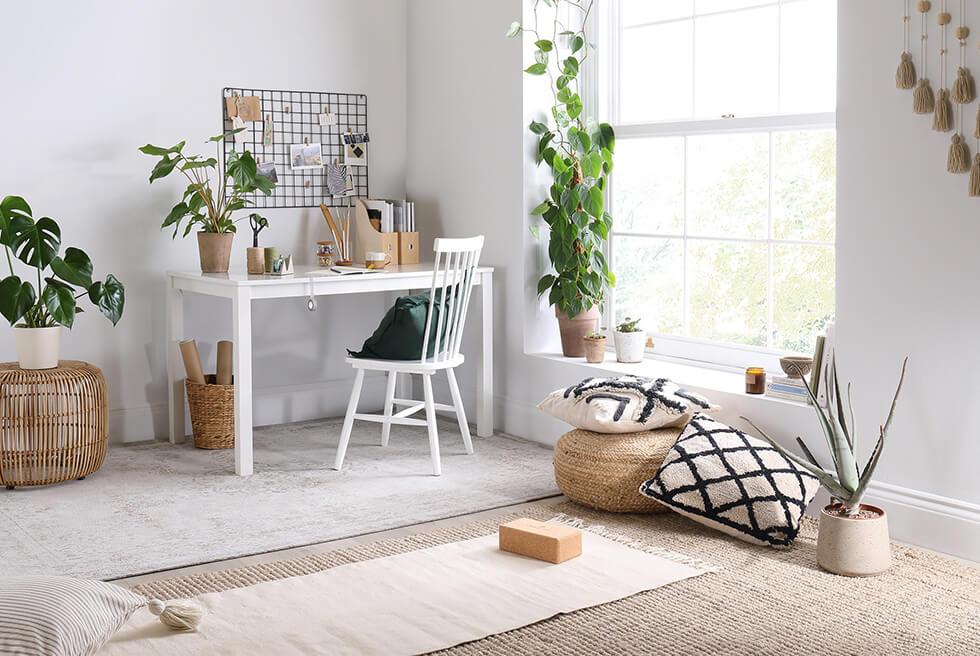 White wooden table and yoga corner in a mindful living interior.