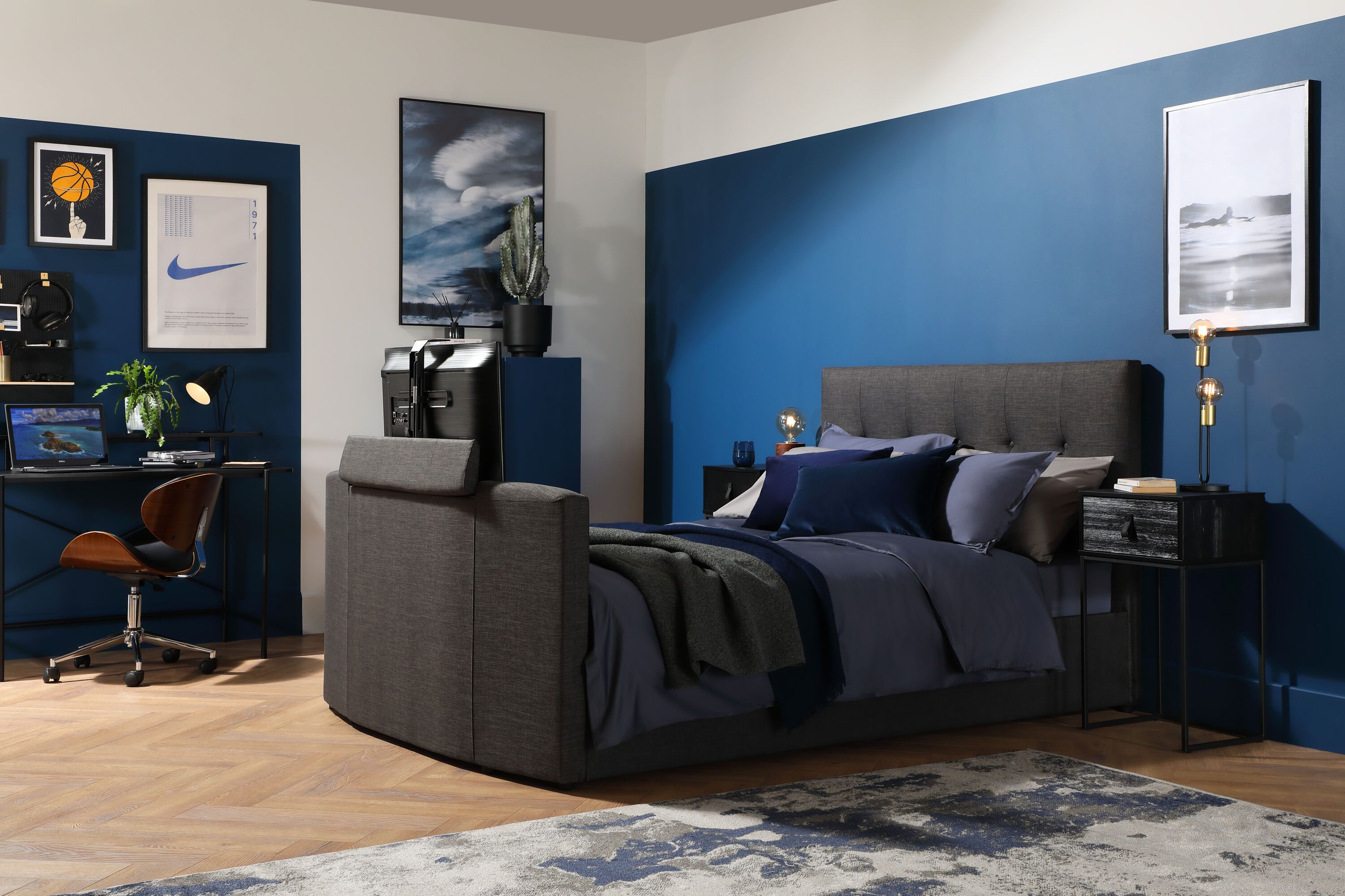 Navy blue bedroom with grey tv bed and feature wall