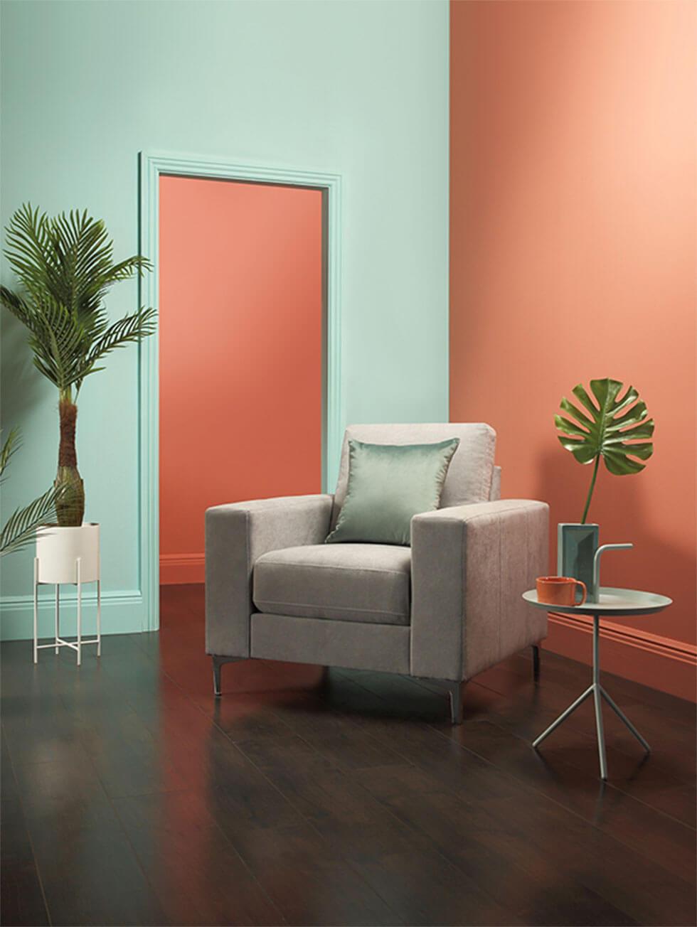 Neo mint and coral colour blocked walls with a light grey armchair