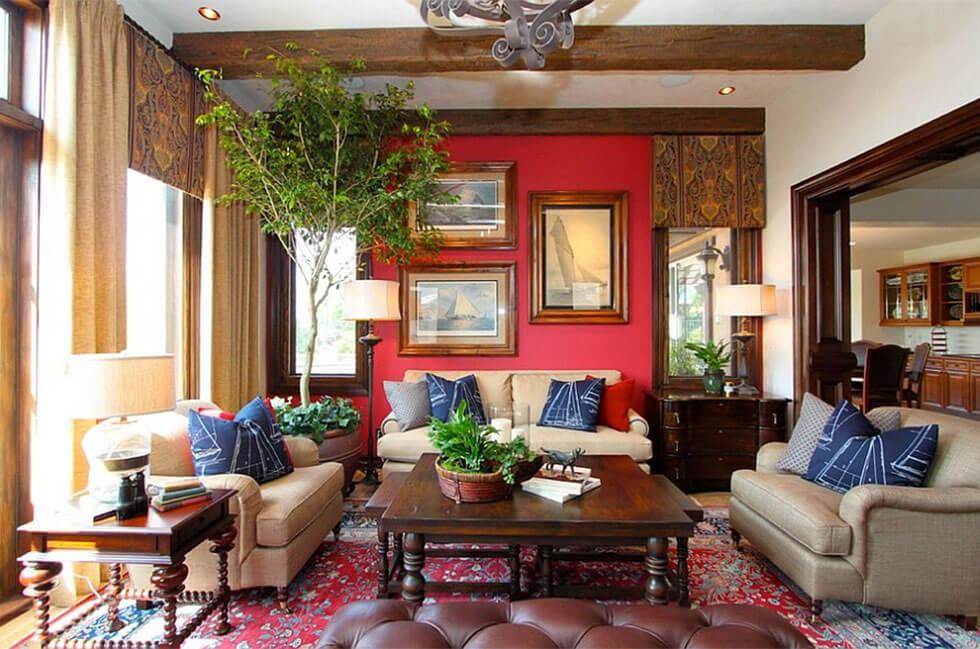 A red and blue living room with blue pillows, neutral sofas and a large indoor plant