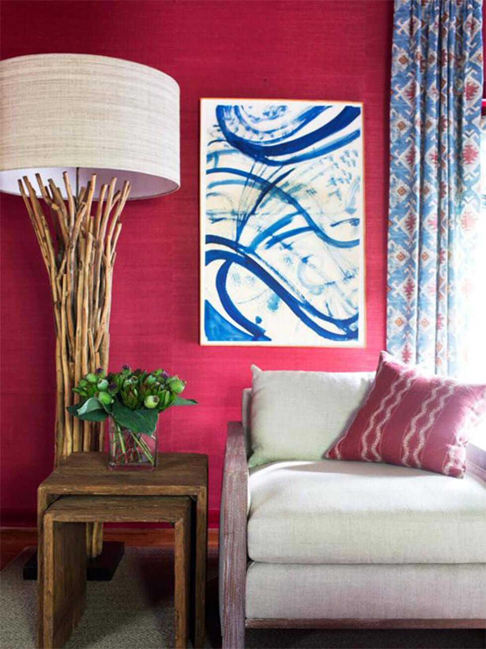 Red living room with a cream sofa, blue and white art, and a large lamp