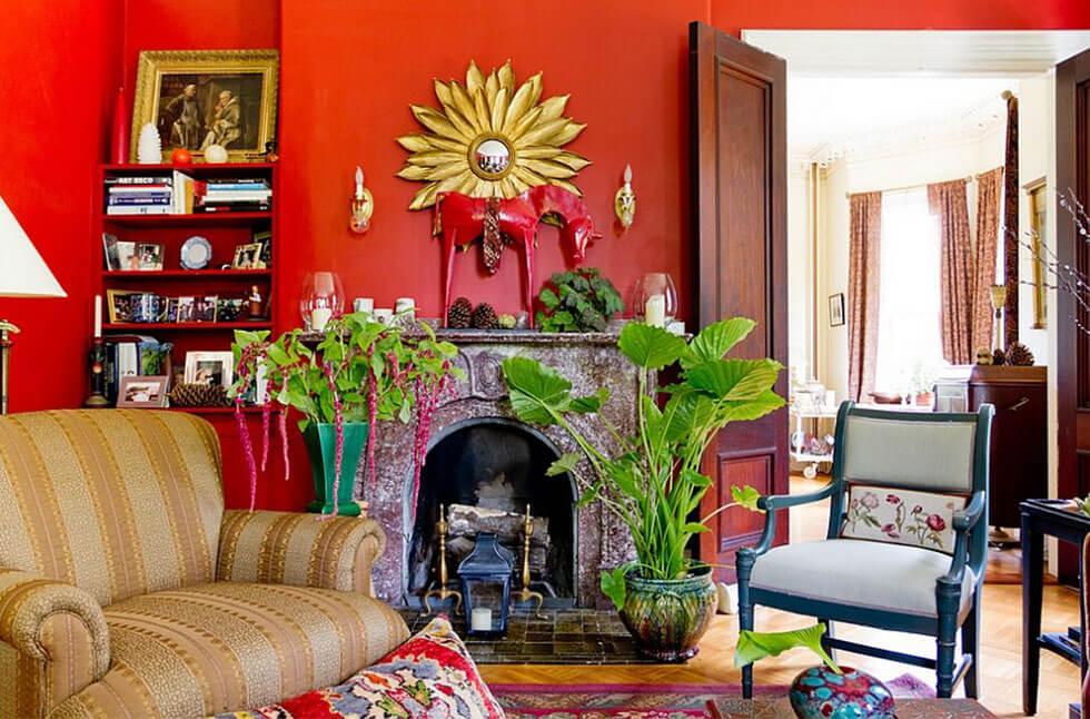 Eclectic red living room with lots of prints, decor and greenery