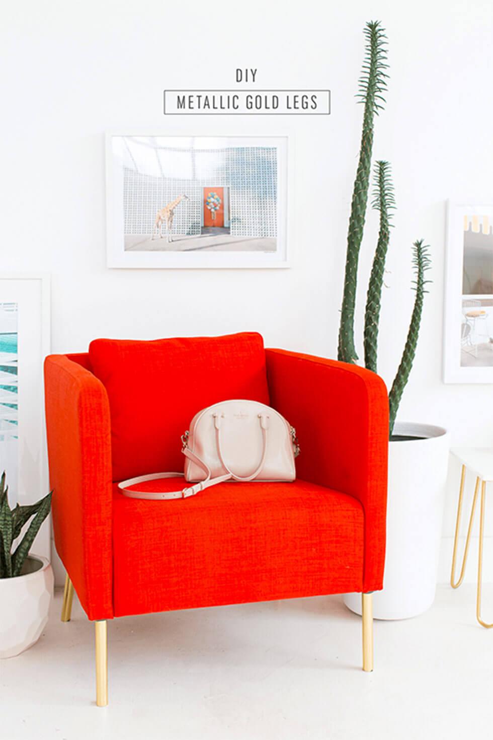Bright red orange armchair with gold legs in a white room