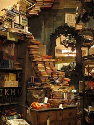 A desk and shelf stacked with books.