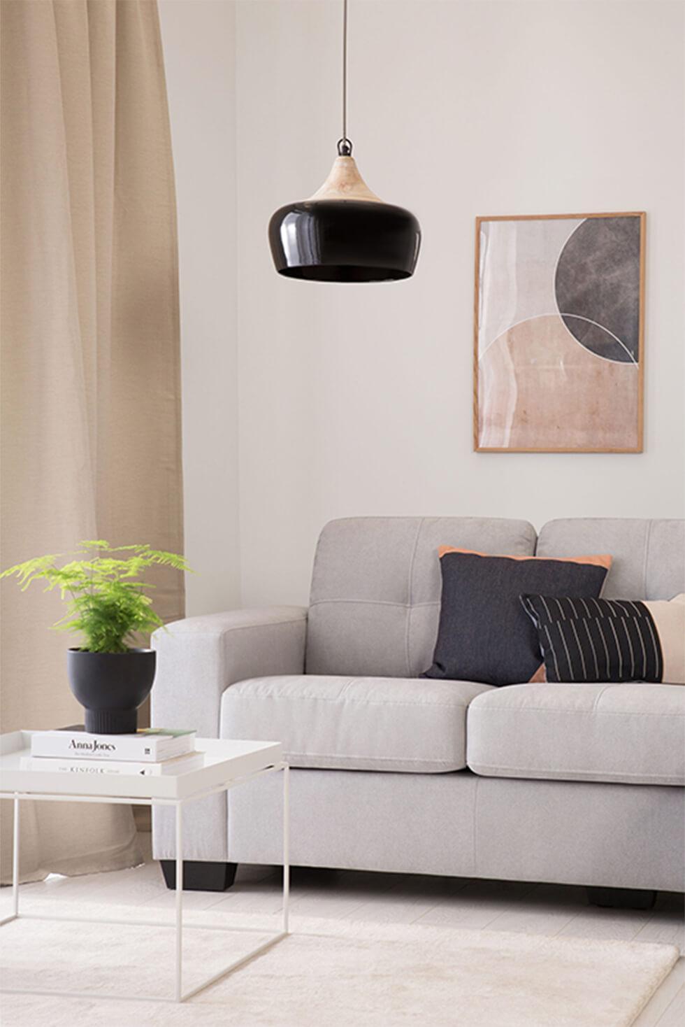 Neutral greige living room with grey sofa, black lamp and white coffee table