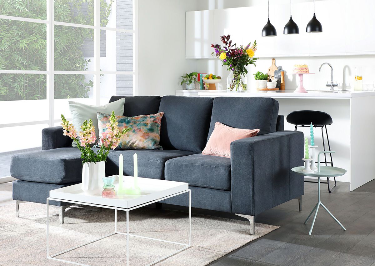 White living room with grey sofa and floral pastel accessories