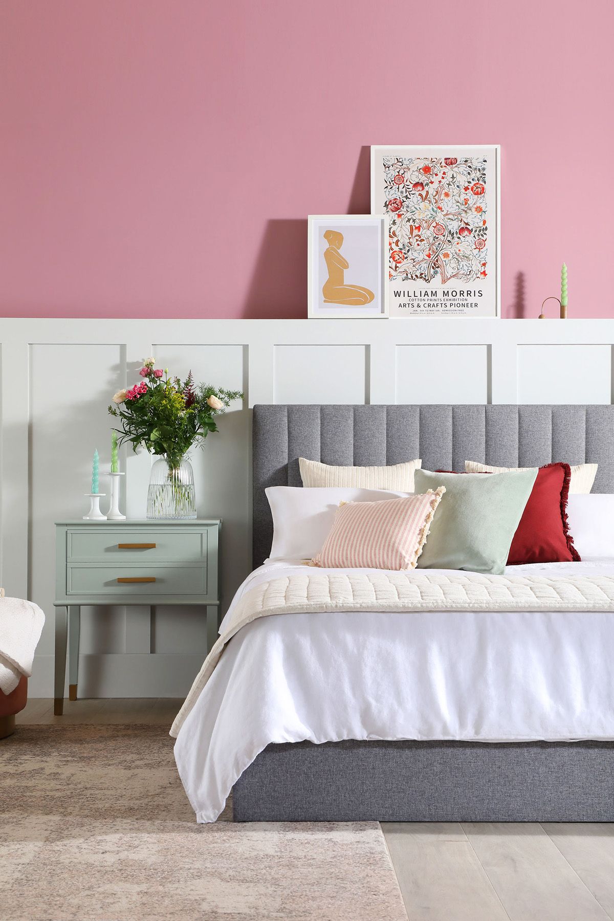 Pink bedroom with grey fabric bed and white wall panelling