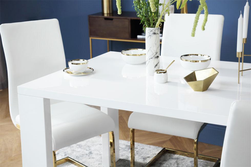 A glossy white dining set with gold decorations and ornaments.