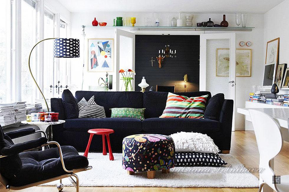 Living room with a monochrome theme and large black sofa.