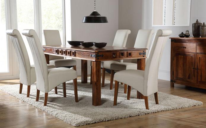 Solid wooden table with white modern leather chairs.
