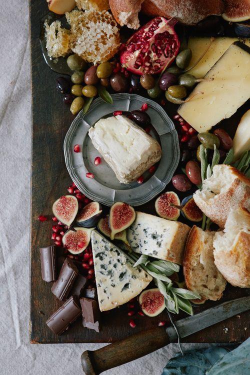 Cheese platter of assorted fruits and cheese.