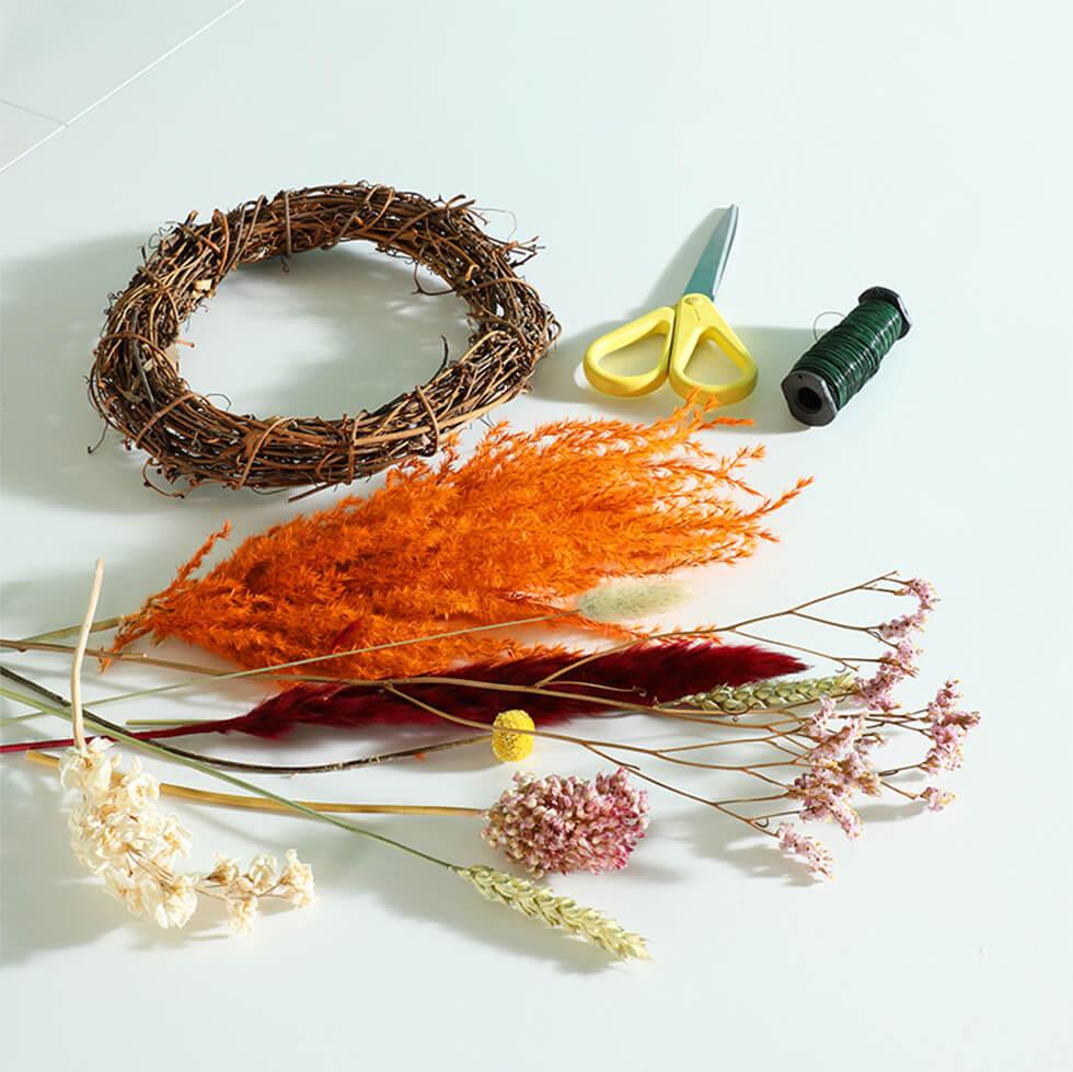 Materials needed to create a spring floral hoop include a rattan hoop, dried flowers and florist wire