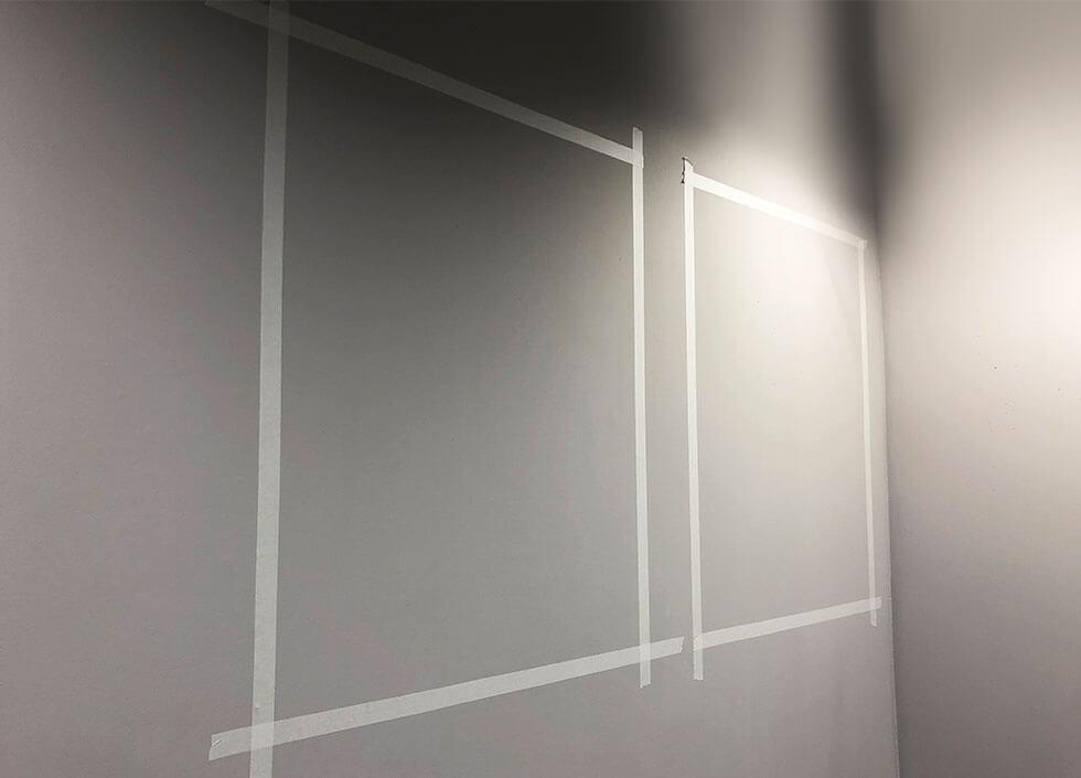 Masking tape on a grey wall.