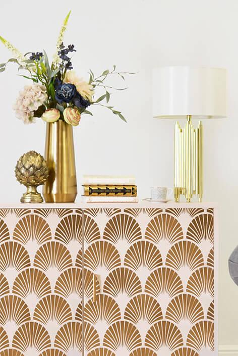 Shot of a white and gold printed sideboard with decorative accessories.