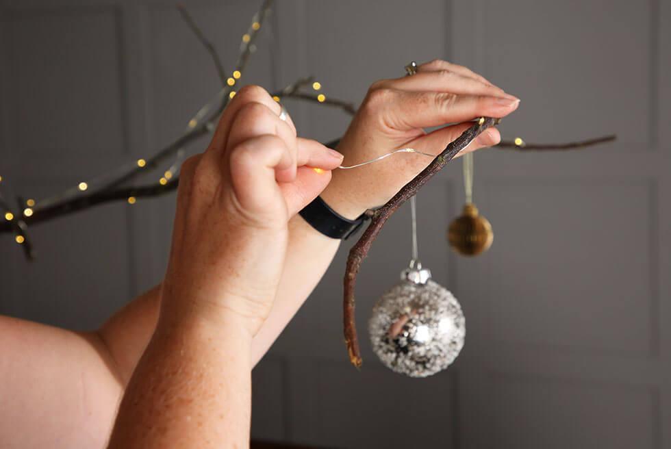 Hanging a bauble on a branch.