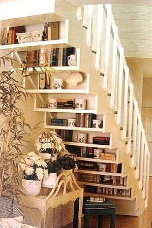 Shelves on the underside of a white staircase.