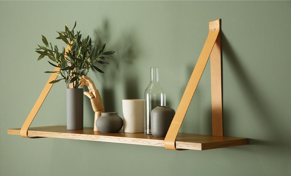 Elegant and minimal leather strap shelf with decorative vases and a plant