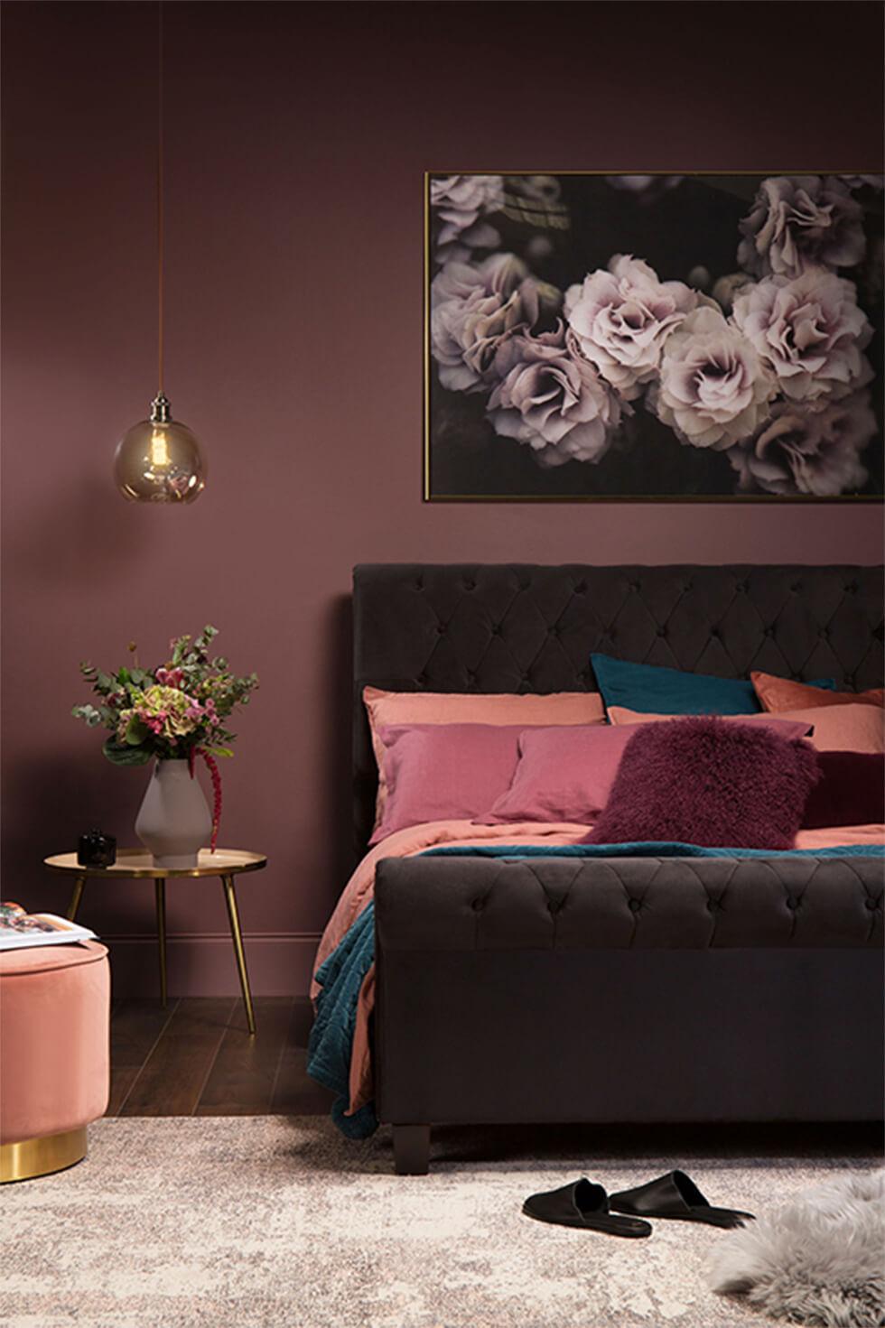 Moody bedroom with velvet bed and dark pink tones