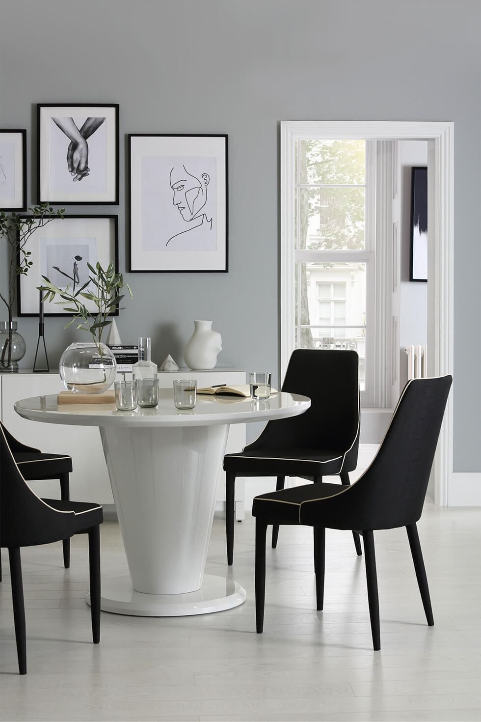 Sophisticated black and white dining set in a dining room with a gallery wall