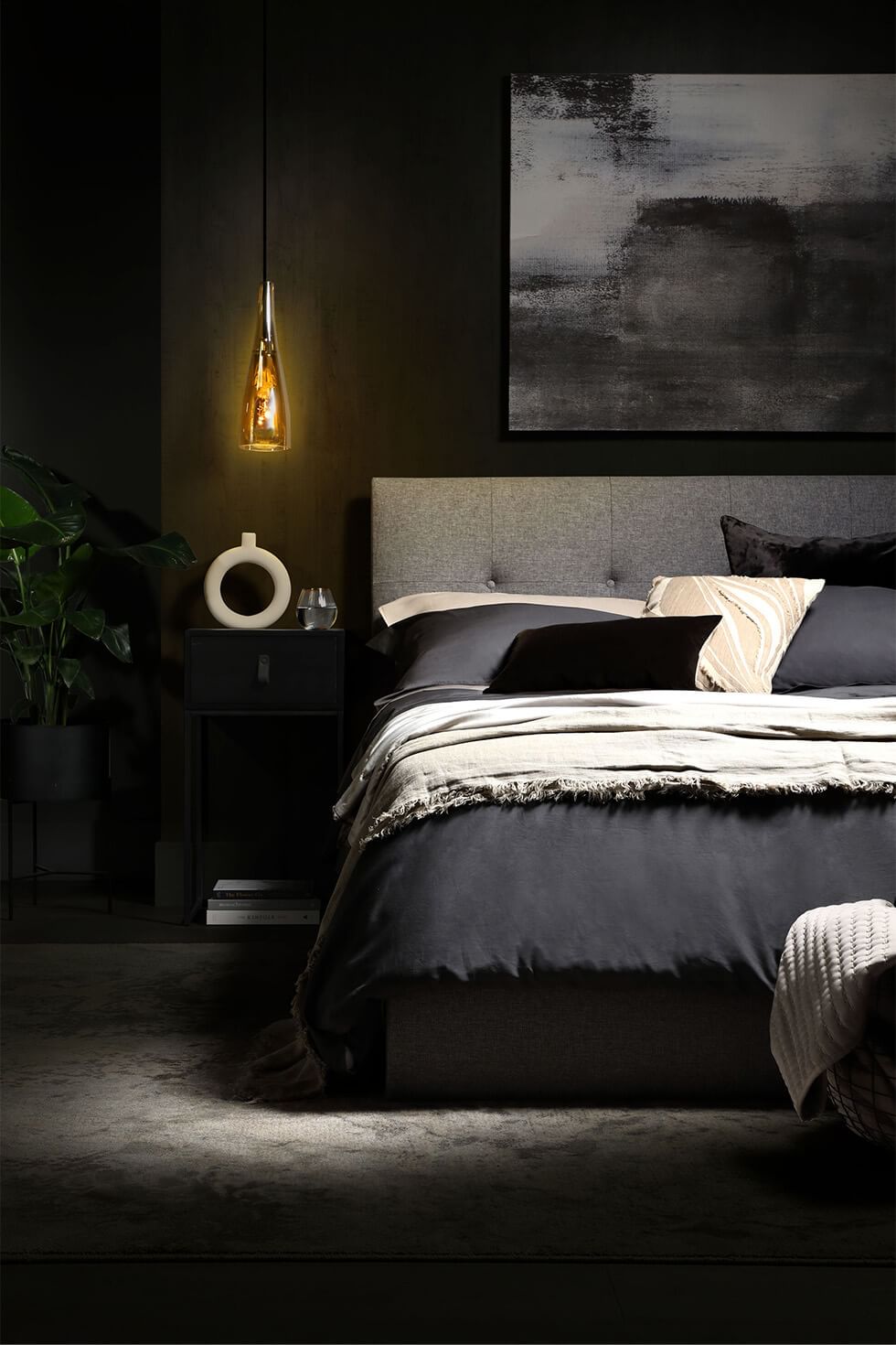 Cosy black bedroom layered with grey bed and accessories