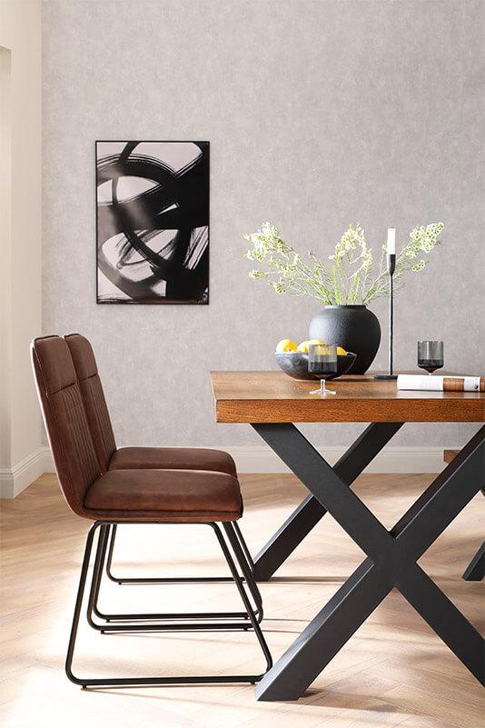 Wooden dining table with black painted legs and brown and black dining chairs